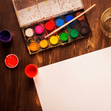 Ahşap masa üzerinde sanatçı araçları