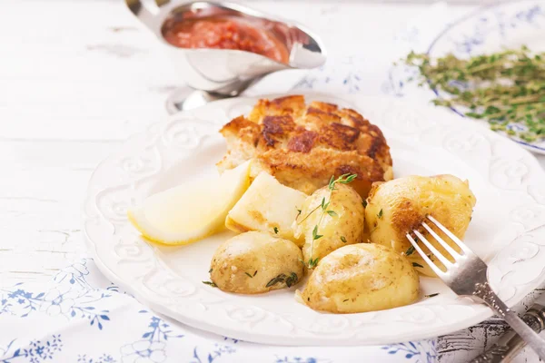 stock image Delicious dinner: baked potatoes with thyme and cutlets