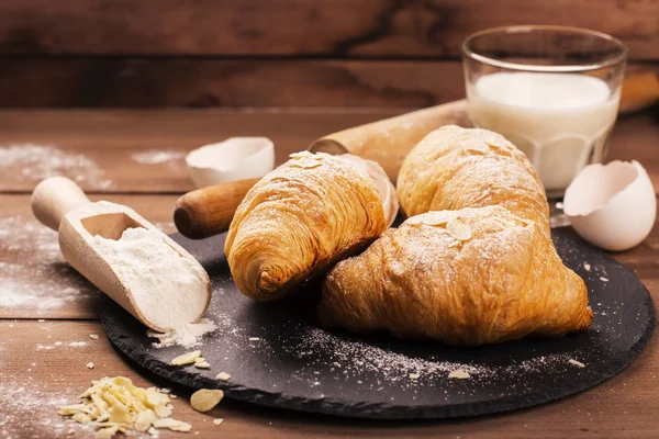 Croissants frescos assados com folhas de amêndoa — Fotografia de Stock