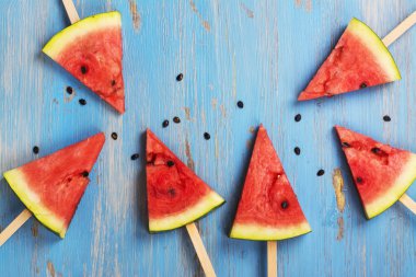 Mavi ahşap arka plan üzerinde karpuz popsicles
