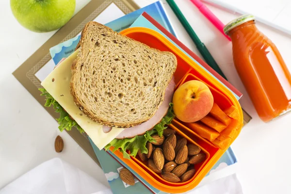 School lunch box with sandwich, fruits and nuts