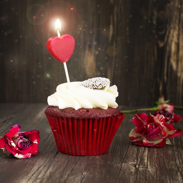 Lahodné červené sametové cupcake s hořící svíčkou — Stock fotografie