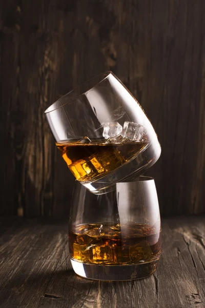 Cognac in glasses over wooden table — Stock Photo, Image