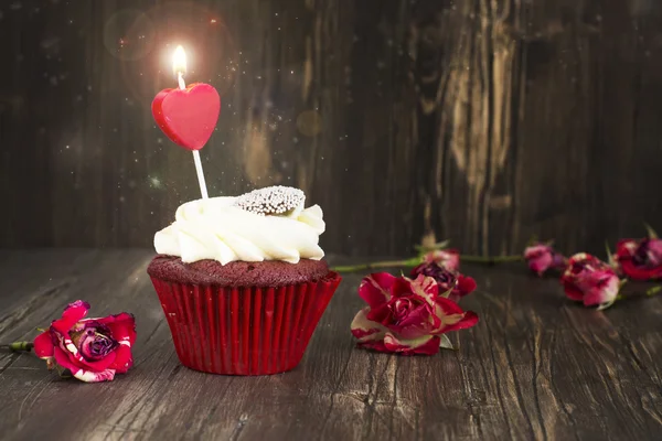 Lahodné červené sametové cupcake s hořící svíčkou — Stock fotografie