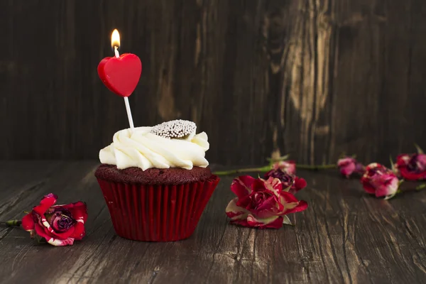 Lahodné červené sametové cupcake s hořící svíčkou — Stock fotografie