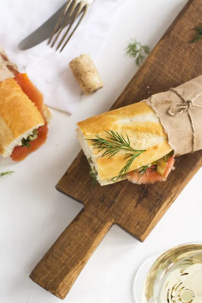 Sanduíches saborosos com salmão defumado sobre mesa branca — Fotografia de Stock