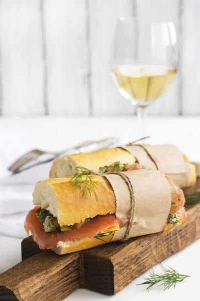 Sanduíches saborosos com salmão defumado sobre mesa branca — Fotografia de Stock