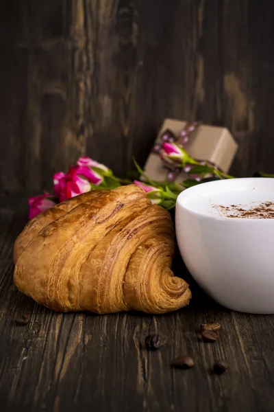 Croissant proaspăt și cappuccino peste masa de lemn — Fotografie, imagine de stoc
