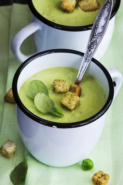 Sopa de ervilha verde em canecas de esmalte — Fotografia de Stock