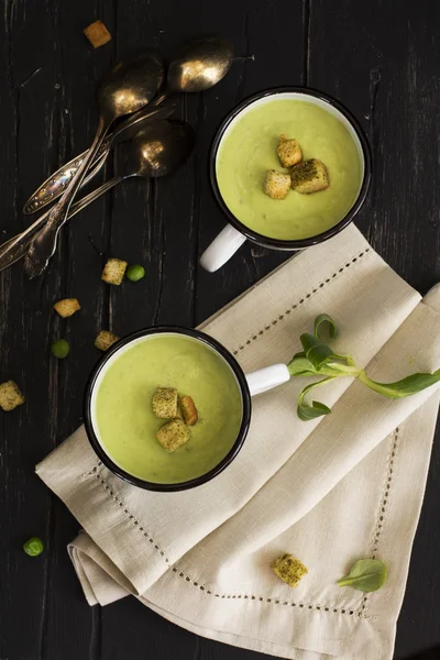 Green spinach and pea soup in enamel mugs — Stock Photo, Image