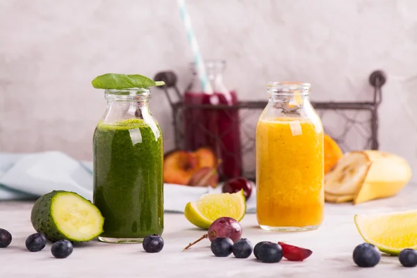 Green, yellow and purple smoothies over stone table — Stock Photo, Image