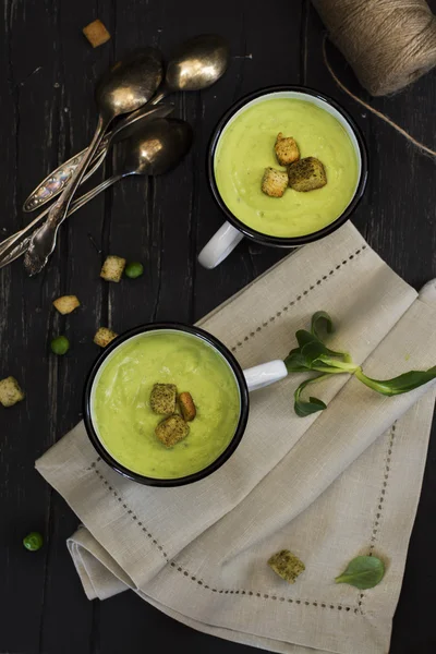 Green pea soup in enamel mugs — Stock Photo, Image