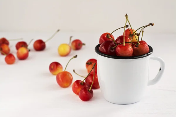 Сладкие вишни в белой эмали кружку — стоковое фото