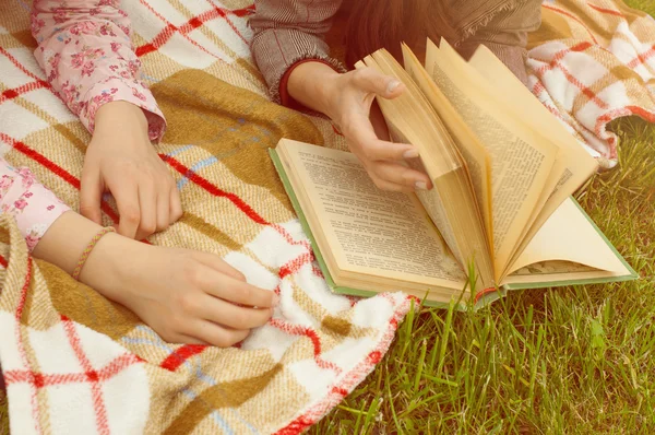 Handen van twee meisjes met een boek — Stockfoto
