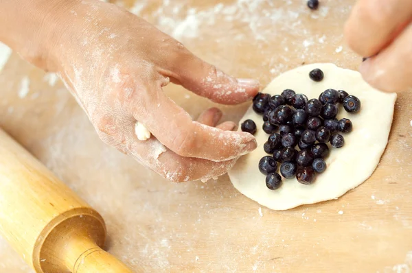 Chef van het gebakje zet blauwe bosbes in deeg — Stockfoto