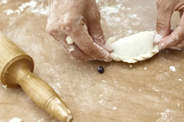 Handen van de banketbakker maken een broodje — Stockfoto