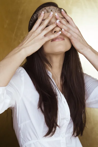 girl closes eyes with her hands