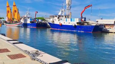 Cesenatico-Italy- 7 Eylül 2025 'te şehir merkezindeki bir kanal boyunca bir yelkenli yatı yola çıkar. Cesenatico 0076 Porto Canale Leonardesco İtalya. Yüksek kaliteli FullHD görüntüler