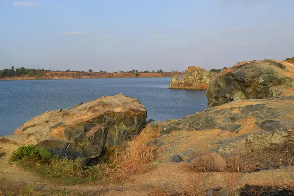 Rocky sjö med några stenar och gräs i banken — Stockfoto