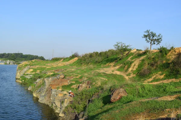 Felsiger See mit Steinen und Gras am Ufer — Stockfoto