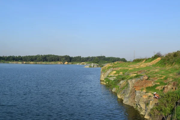 Skalista jeziora z niektórych kamieni i trawa w banku — Zdjęcie stockowe
