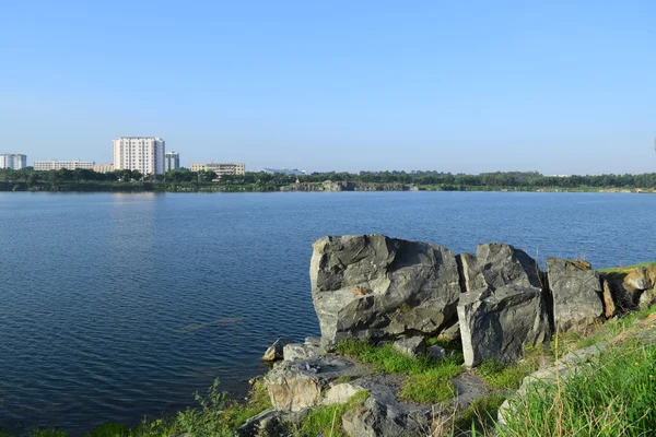 Skalnatá jezera s některými kameny a trávy v bance — Stock fotografie