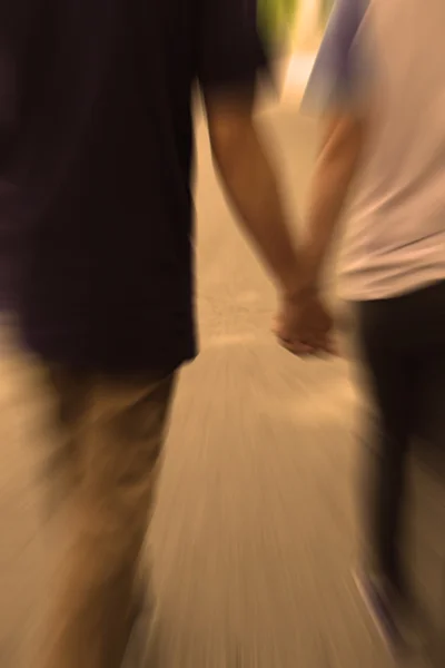 Milující pár se drží rukou při chůzi — Stock fotografie