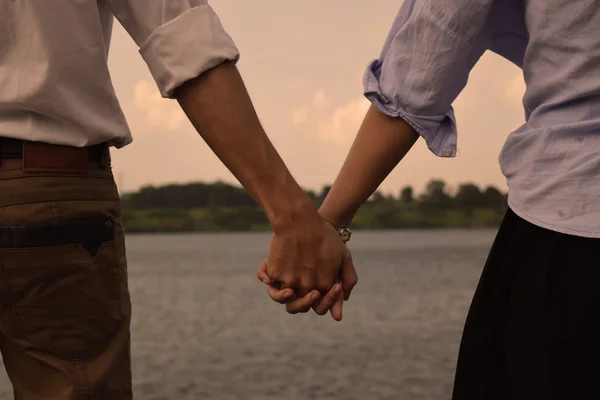 Любляча пара тримає руки під час ходьби Ліцензійні Стокові Зображення