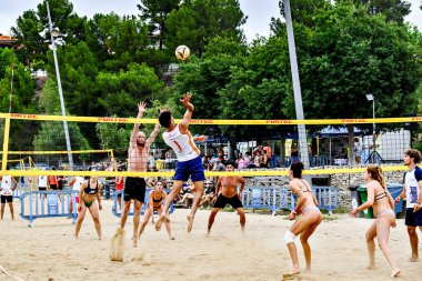 Igualada, Barcelona, İspanya; 13 Temmuz 2024: Şehirde plaj voleybolu oynayan bir grup genç. Spor ve eğlence..