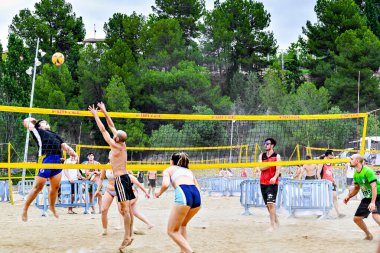 Igualada, Barcelona, İspanya; 13 Temmuz 2024: Şehirde plaj voleybolu oynayan bir grup genç. Spor ve eğlence..