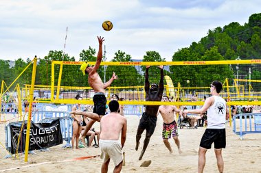 Igualada, Barcelona, İspanya; 13 Temmuz 2024: Şehirde plaj voleybolu oynayan bir grup genç. Spor ve eğlence..