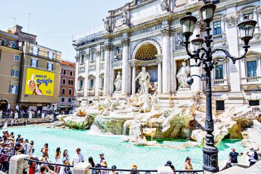 Roma, İtalya; 19 Temmuz 2025: Roma 'daki ünlü ve görkemli Trevi Çeşmesini ziyaret eden turistler