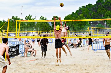 Igualada, Barcelona, İspanya; 13 Temmuz 2024: Şehirde plaj voleybolu oynayan bir grup genç. Spor ve eğlence..