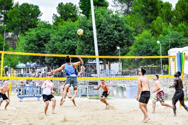 Igualada, Barcelona, İspanya; 13 Temmuz 2024: Şehirde plaj voleybolu oynayan bir grup genç. Spor ve eğlence..