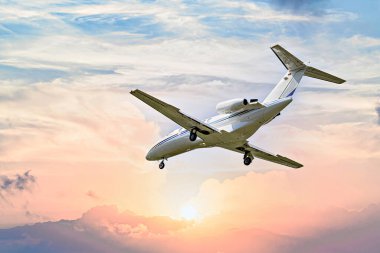 Günbatımı gökyüzünün altında uçan özel bir iş jeti
