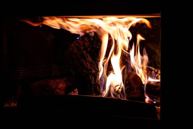 Oturma odasında odun ateşiyle şömine, rahat ve sıcak bir ev.