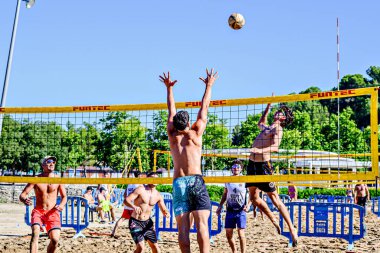 Igualada, Barcelona, İspanya; 17 Mayıs 2025: Şehirde plaj voleybolu oynayan bir grup genç. Spor ve eğlence..