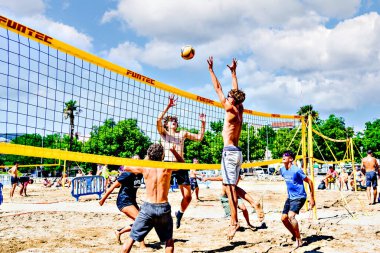 Igualada, Barcelona, İspanya; 17 Mayıs 2025: Şehirde plaj voleybolu oynayan bir grup genç. Spor ve eğlence..