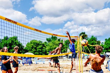 Igualada, Barcelona, İspanya; 17 Mayıs 2025: Şehirde plaj voleybolu oynayan bir grup genç. Spor ve eğlence..