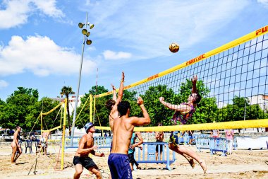 Igualada, Barcelona, İspanya; 17 Mayıs 2025: Şehirde plaj voleybolu oynayan bir grup genç. Spor ve eğlence..