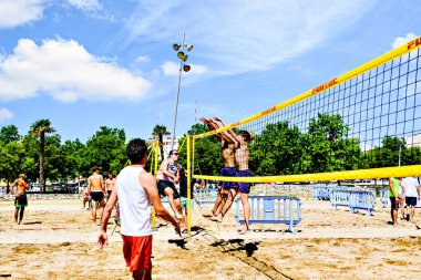 Igualada, Barcelona, İspanya; 17 Mayıs 2025: Şehirde plaj voleybolu oynayan bir grup genç. Spor ve eğlence..
