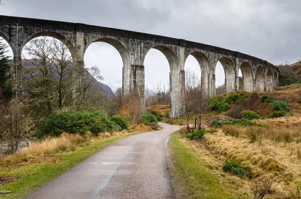 Camino rural que corre bajo un viaducto ferroviario — Foto de Stock