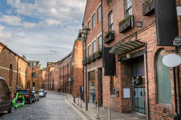 Bâtiments en brique rénovés le long d'une rue pavée — Photo