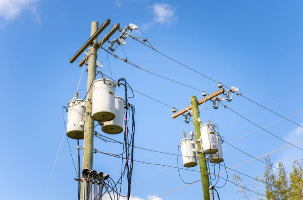 Postes de electricidad contra el cielo azul — Foto de Stock