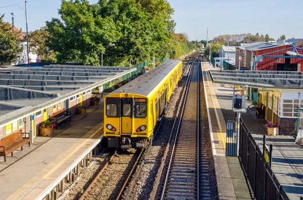 Sárga személyszállító vonat egy állomáson — Stock Fotó
