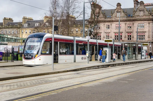 Menschen steigen an einem bewölkten Wintertag in der Innenstadt von Edinburgh in die Straßenbahn ein und aus — Stockfoto