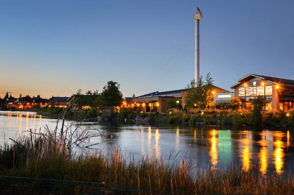 Riverside budovy za soumraku a odraz ve vodě — Stock fotografie