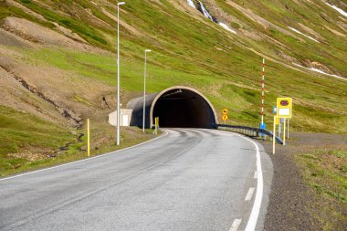 Güneşli bir yaz gününde İzlanda 'da bir dağ tünelinin girişinin görüntüsü