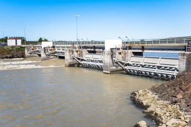 Açık bir yaz gününde İzlanda nehri boyunca uzanan küçük bir hidroelektrik santrali.