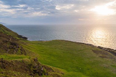 Atlantik Okyanusu 'na bakan çimenli uçurum Kuzey Buz Denizi' nde gece yarısı güneşiyle aydınlanıyor.